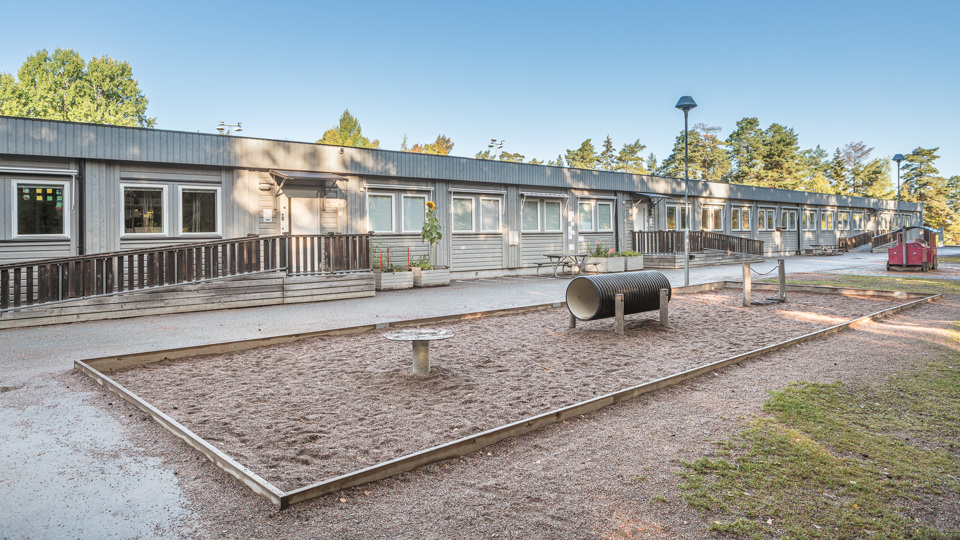 Uppsävja Förskolas skolgård och en grå byggnad
