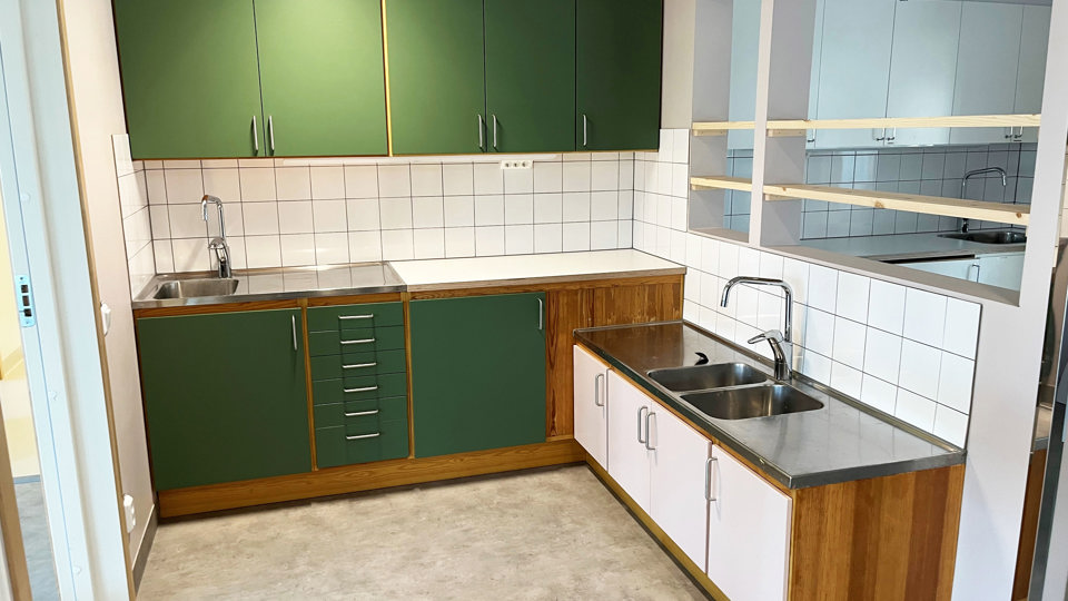 Nyrenoverad köksmiljö på förskola, med omlackade gröna skåpluckor.