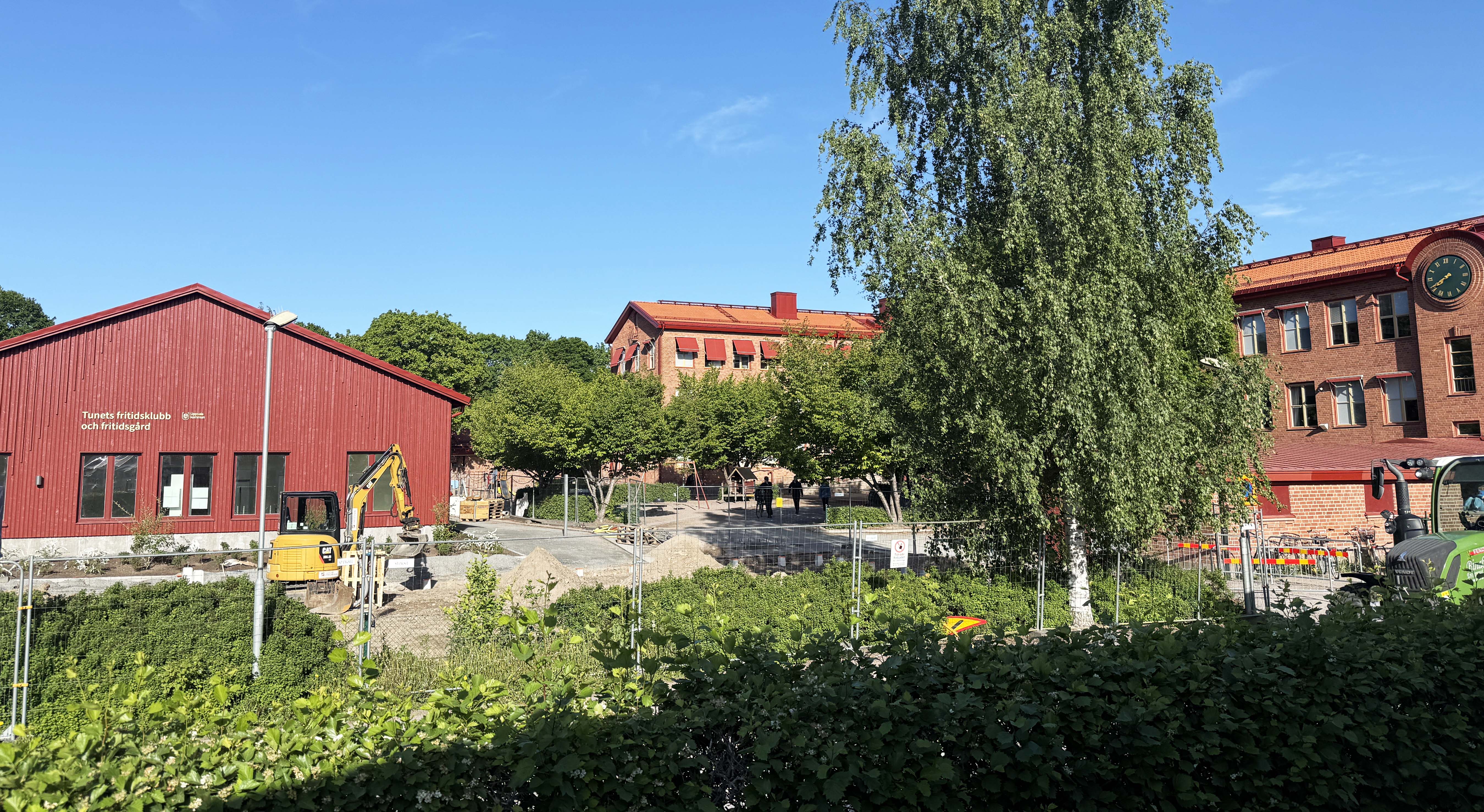 Byggnation av en nytt skolhus med röd träfasad.