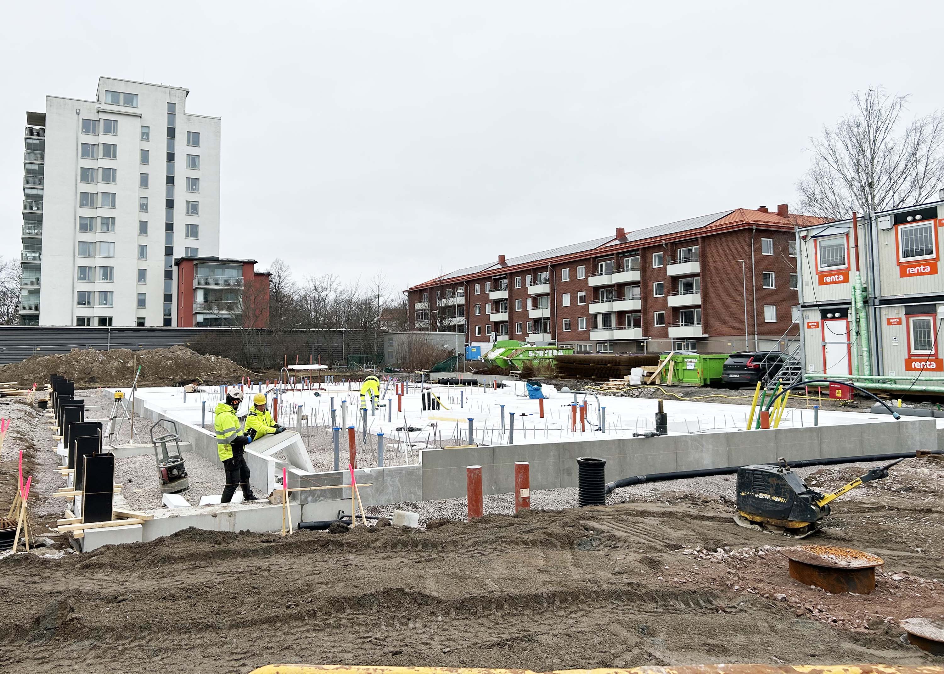 Byggarbetare jobbar med grunden till en byggnad.