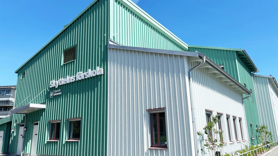 Nybyggd förskola med träfasad i vit och turkos färg.