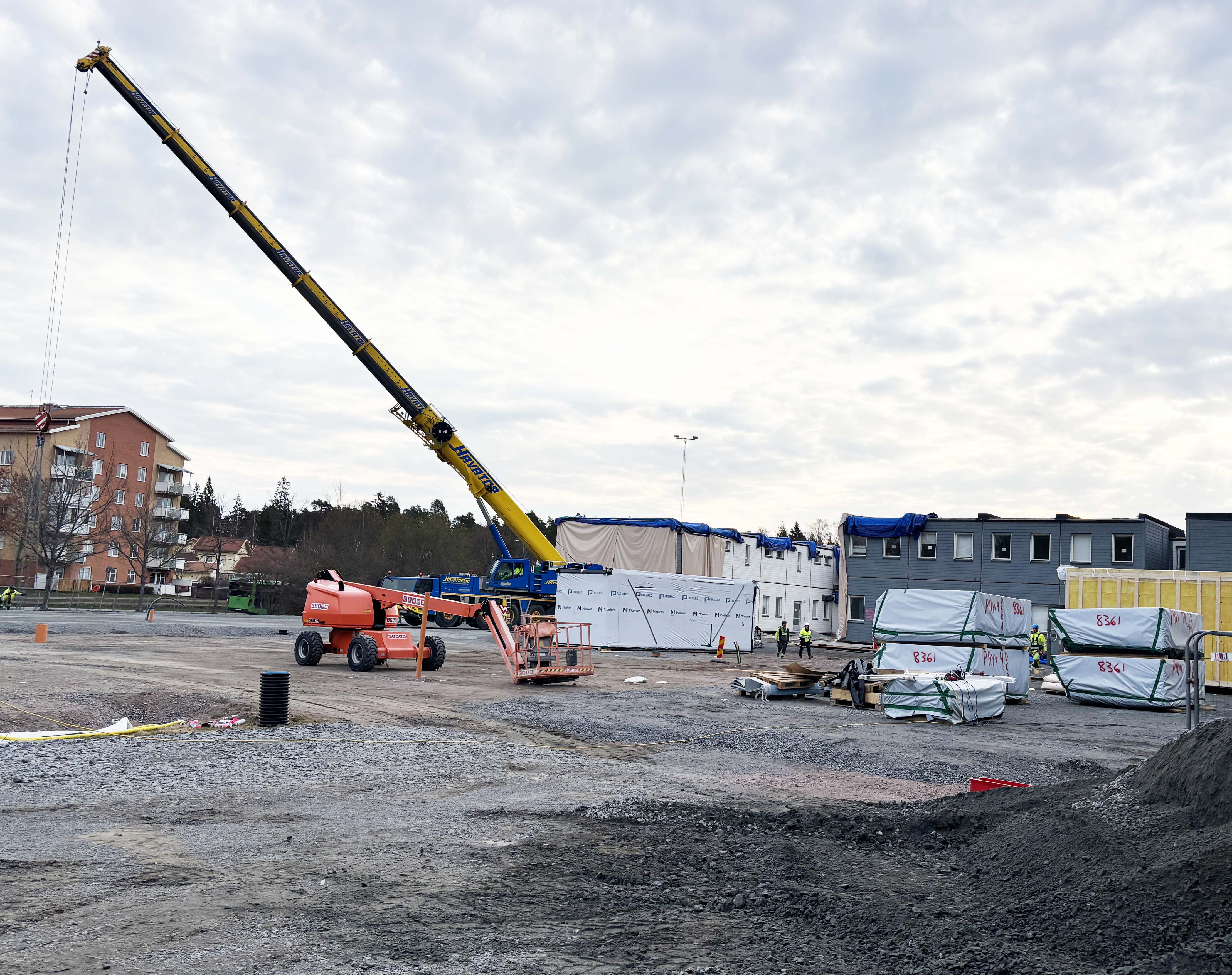 Byggnation av en modulskola med hjälp av en lyftkran.