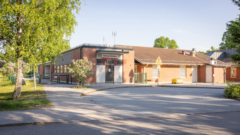 Förskolebyggnad i brunt tegel med en vändplats i förgrunden.