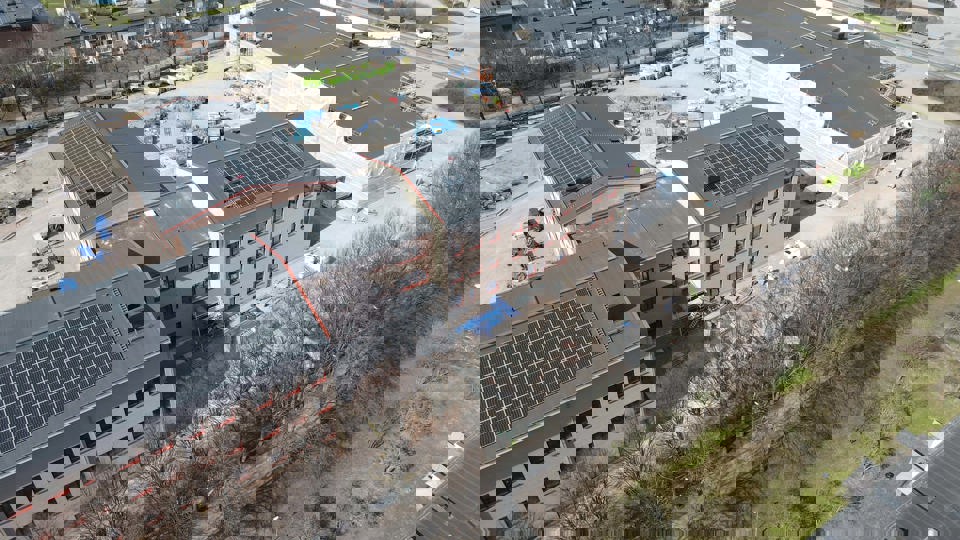 Flygbild över byggplats med omgivande bebyggelse