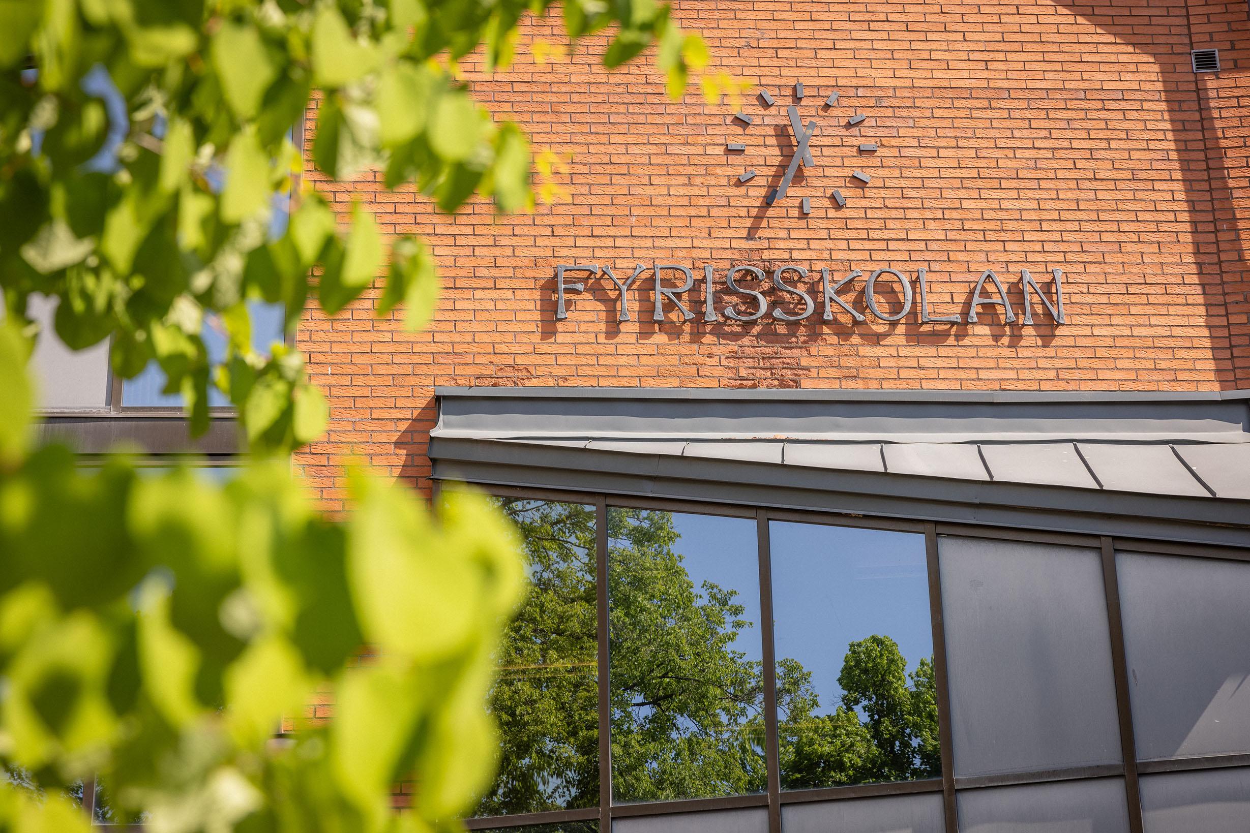 Fasad i brunt tegel med skolskylt