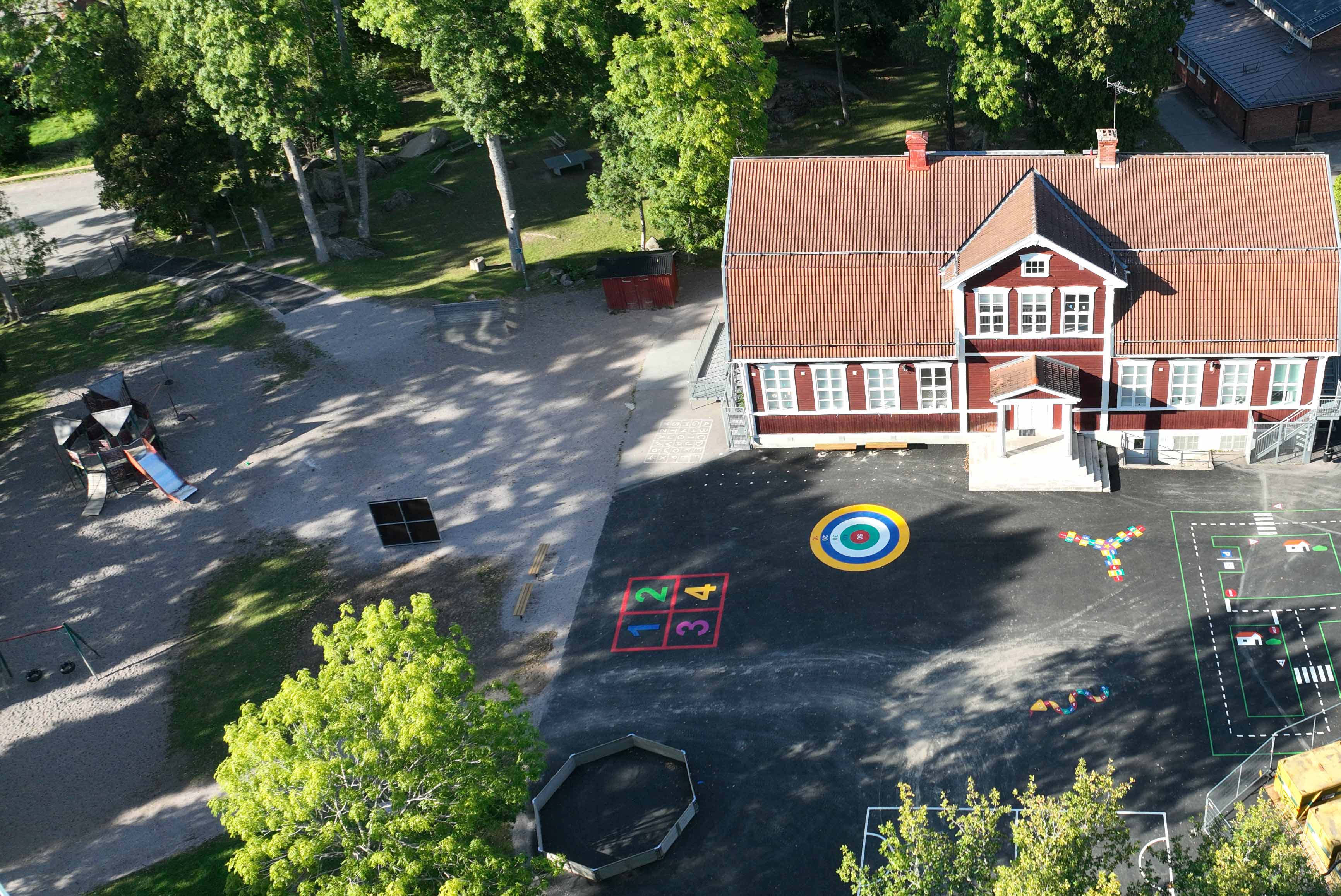 Flygvy över nyrenoverad skolgård, med asfaltsmålningar i färg.