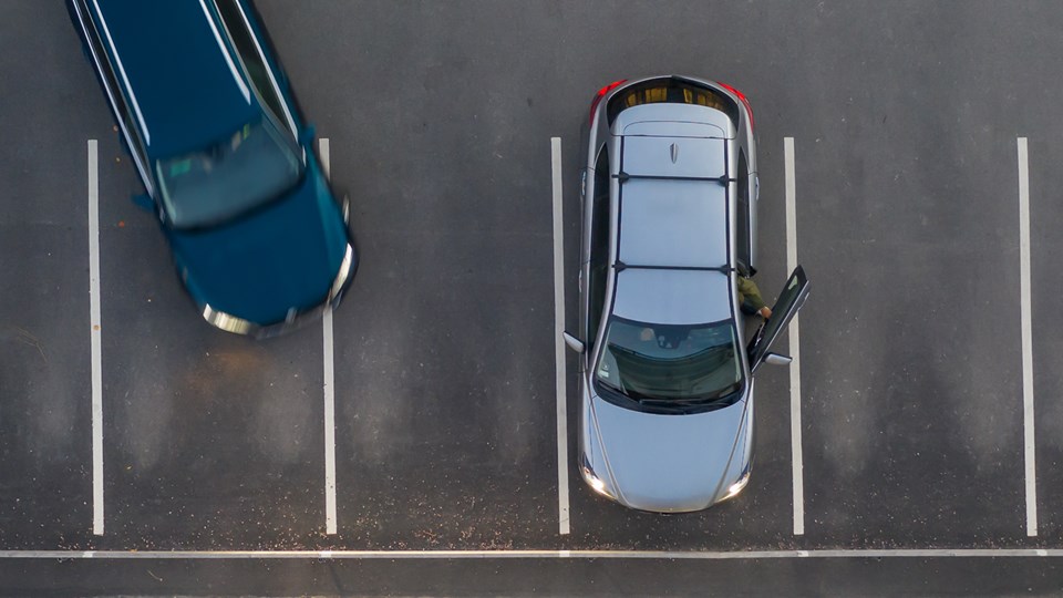 Bilar parkerade på parkeringsplats sedda ovanifrån.