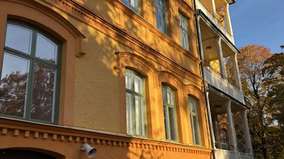 Nyrenoverad gul fasad på gammal skola.