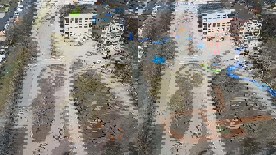 Flygbild över byggplats med omgivande bebyggelse