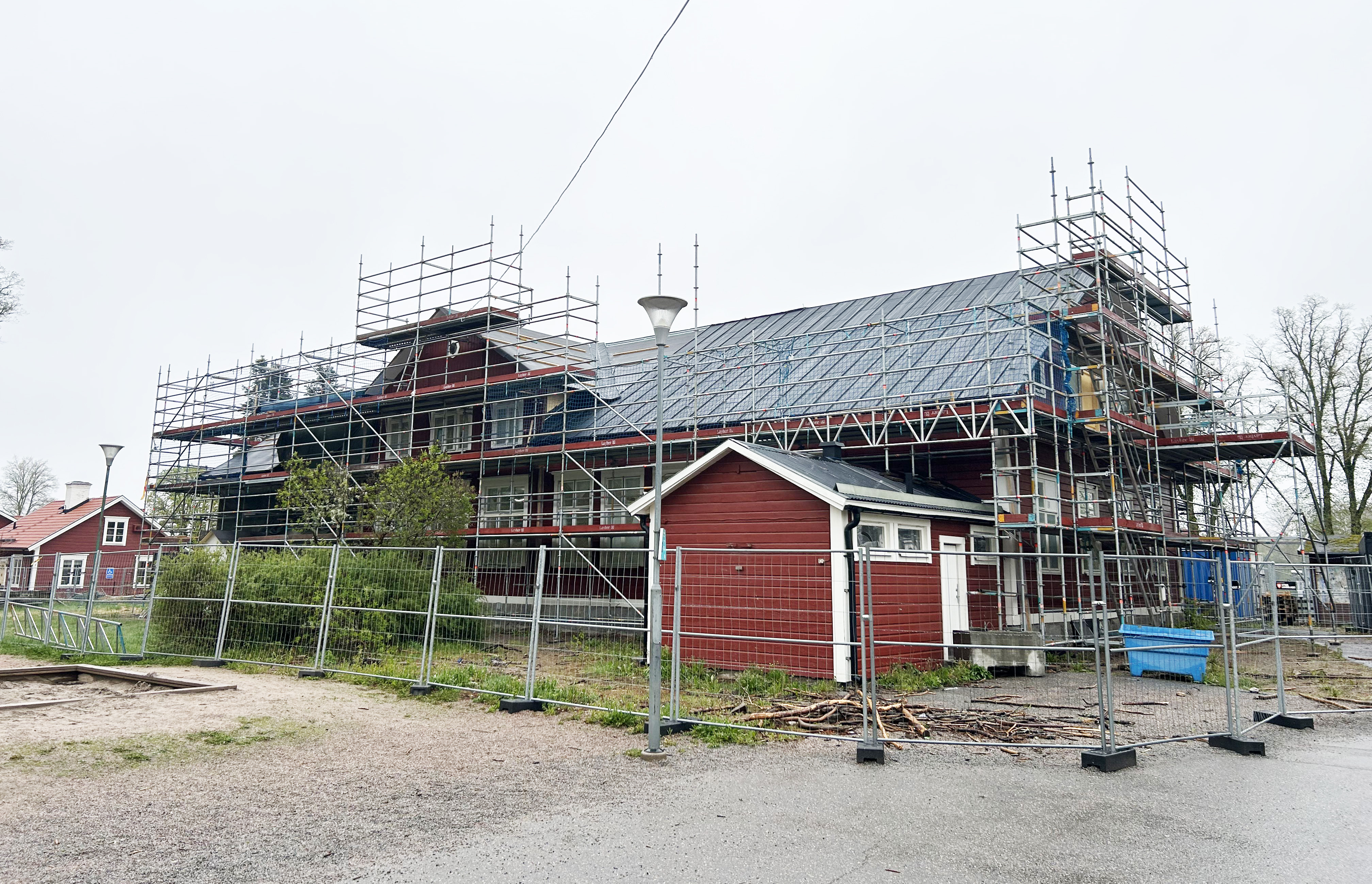 Röd träbyggnad med byggnadsställning.
