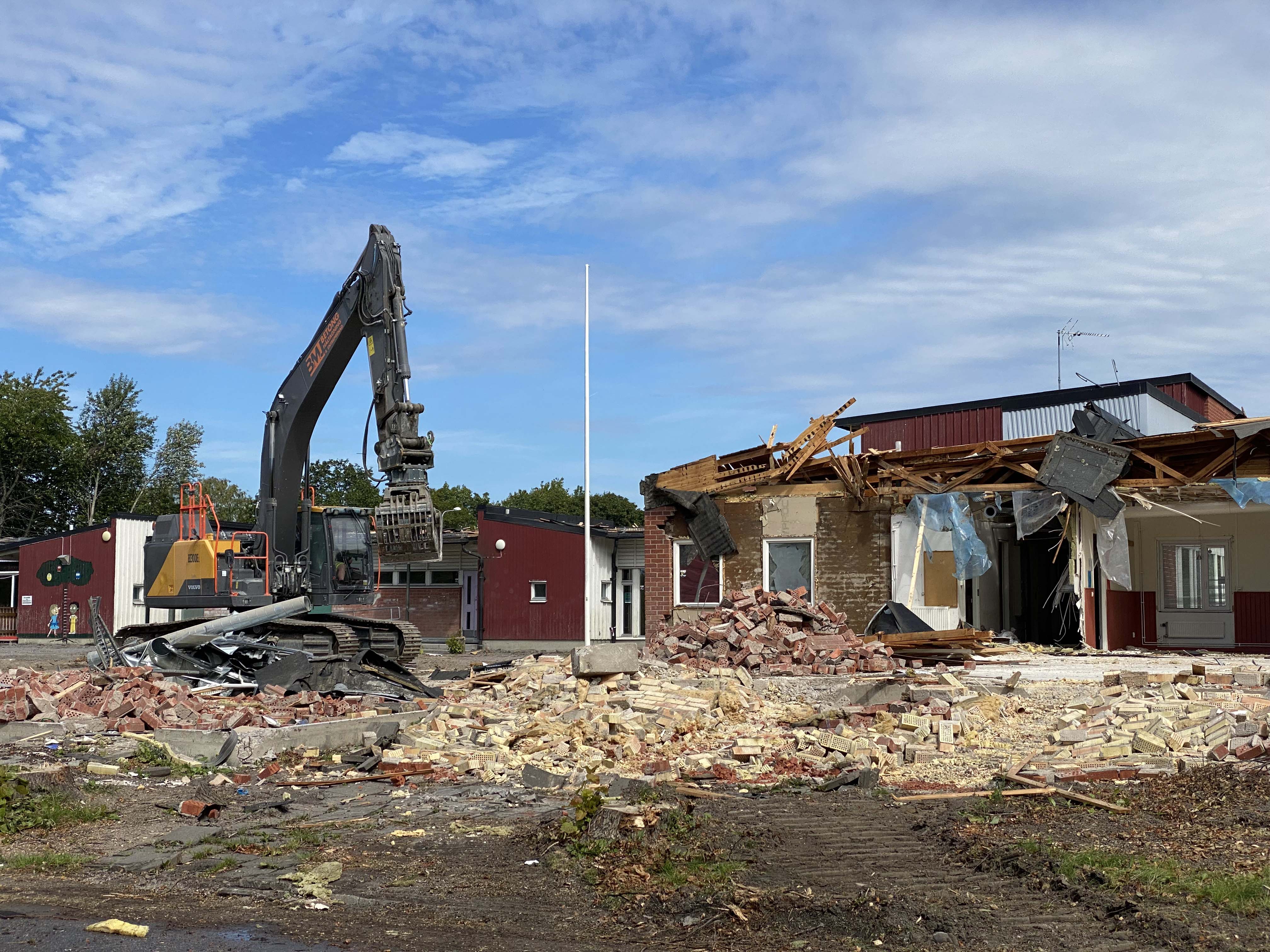 Grävmaskin som river en gammal skola.