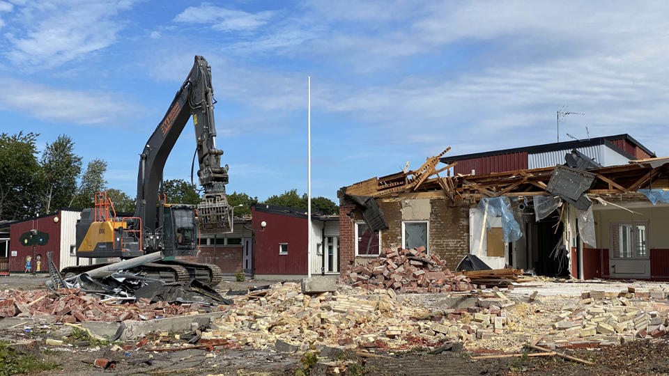 Grävmaskin som river en gammal skola.